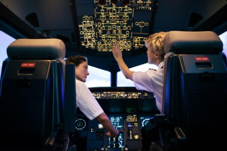 Trainee Pilot Adjusting Switches While Instructor