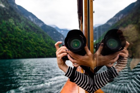 Woman photographing mountain from a boat