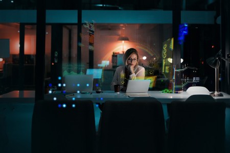 EY late night businesswoman at desk with laptop