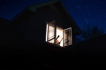 Child pointing to the stars through the window