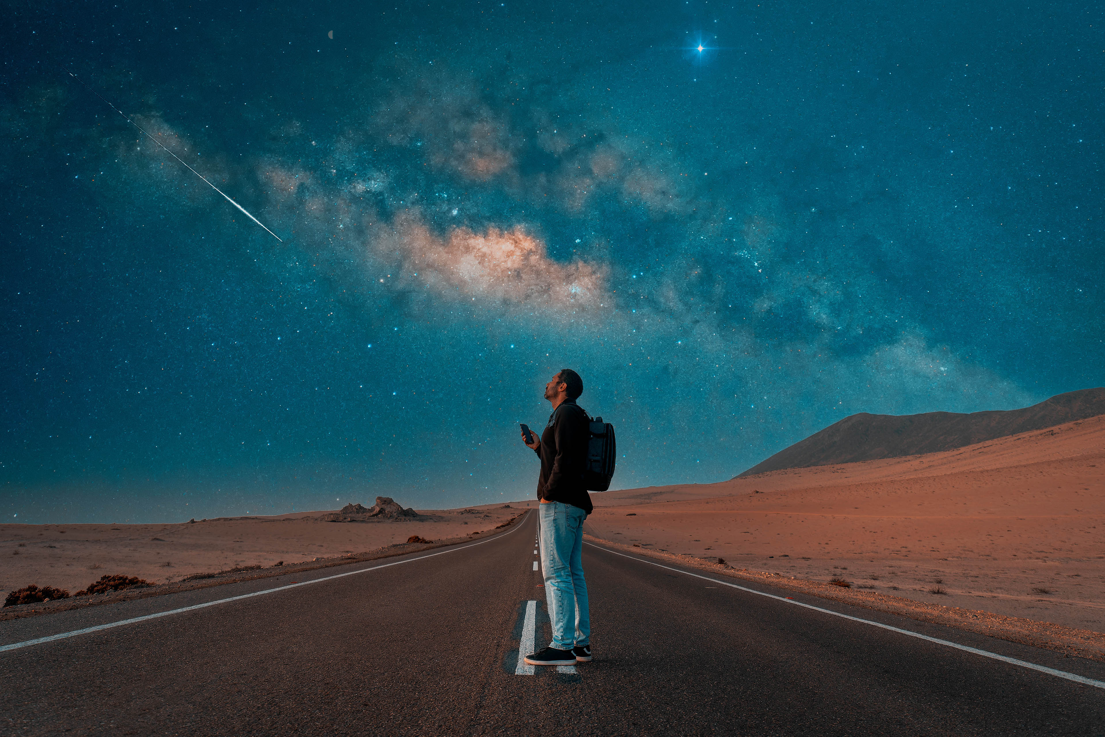 Person standing on the road under milky way at night