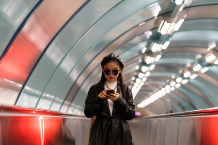 Korean girl posting to social media while riding escalator
