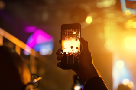 Viewer shoot video on a smartphone at a concert.