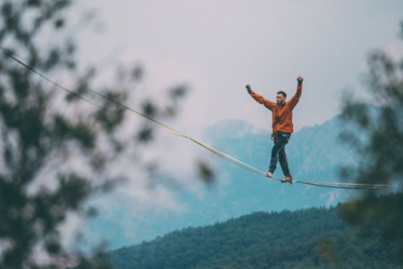 Male balancing highline in mountains