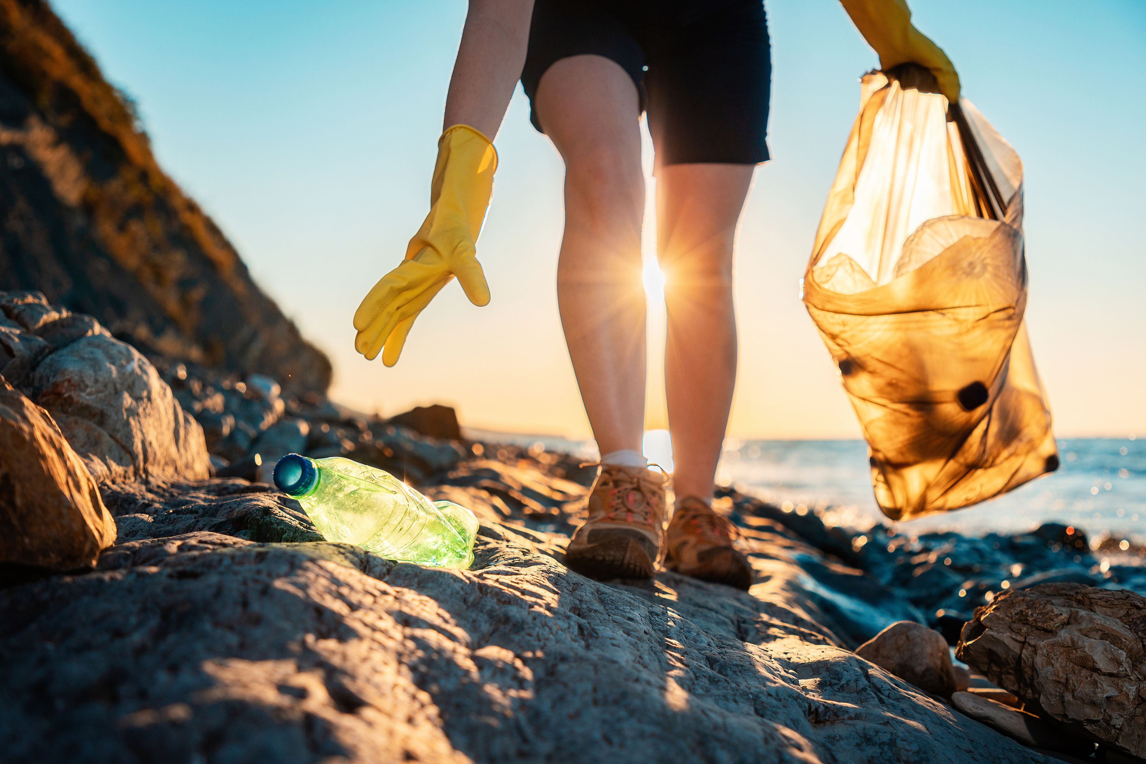 https://assets.ey.com/content/dam/ey-sites/ey-com/en_us/topics/climate-change-sustainability-services/ey-a-volunteer-collects-plastic-bottles-on-the-ocean-shore.jpg