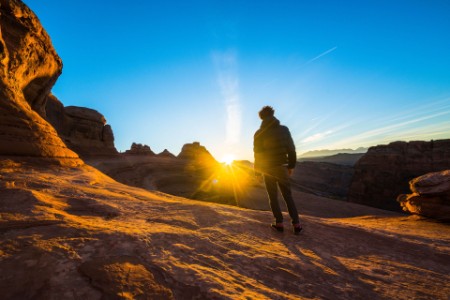 Man admiring the sunrise in the red canyon Utah