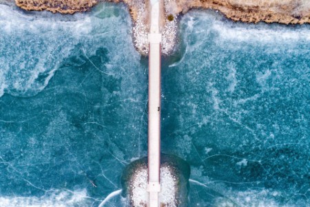 aerial car crossing bridge over frozen waterway