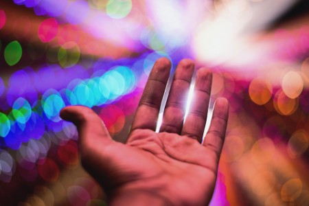 Close-Up Of Hand Against Illuminated Lights