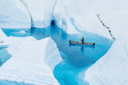 Ice climber canoeing narrow canyons