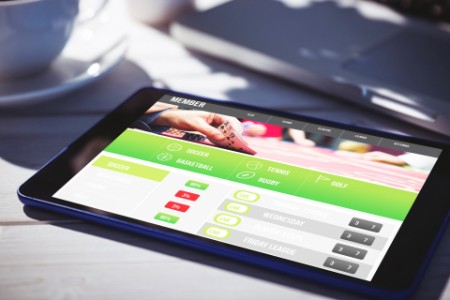 Gambling app screen against tablet and laptop