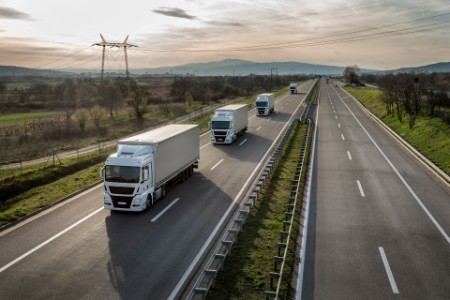Caravan of trucks in line on a country highway