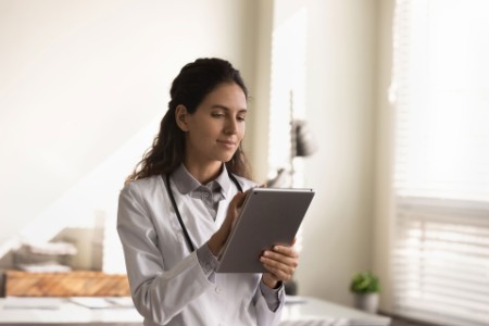 EY - Female doctor work on modern tablet in clinic