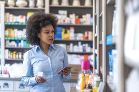 Woman uses smart phone while in pharmacy