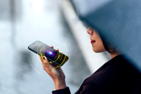 Woman using voice-assistan on smartphone in the rain