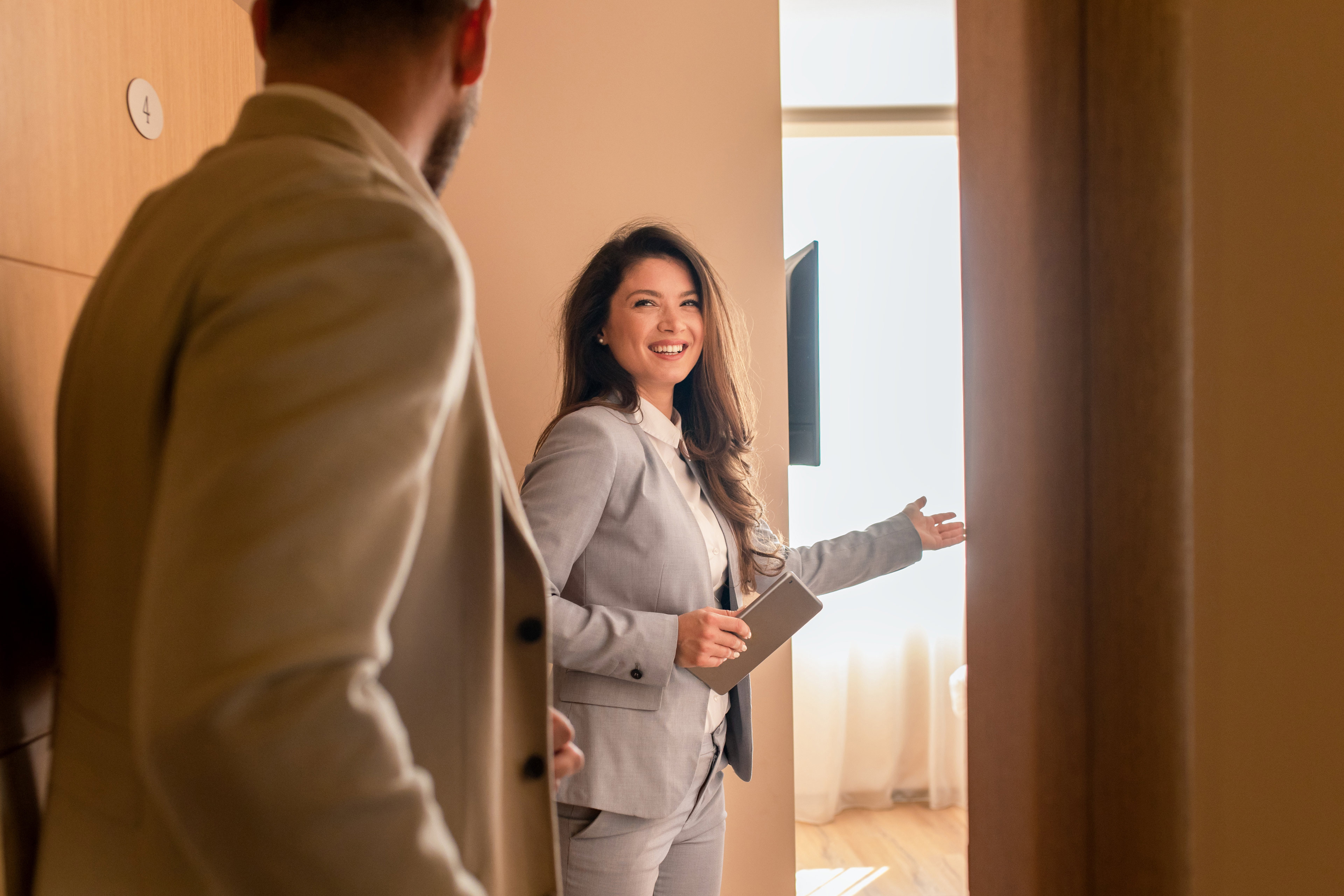 https://assets.ey.com/content/dam/ey-sites/ey-com/en_us/topics/real-estate-hospitality-and-construction/ey-young-businessman-check-in-in-hotel-smiling-female-receptionist-showing-him-available-rooms.jpg