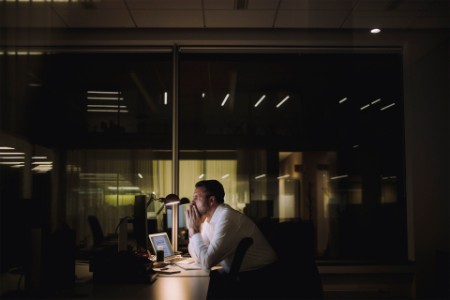 Businessman concentrating while working overtime in office at night