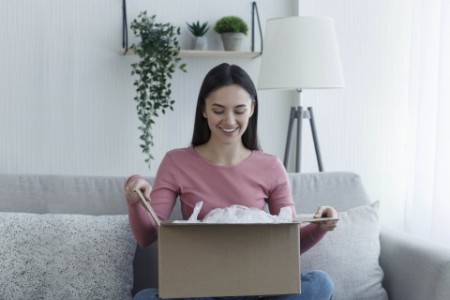 Woman consumer opening package at home