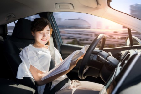 Young woman reading a magazine in autonomous car