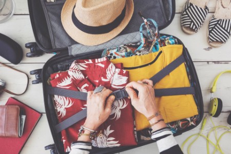 ey-woman-hand-preparing-summer-luggage