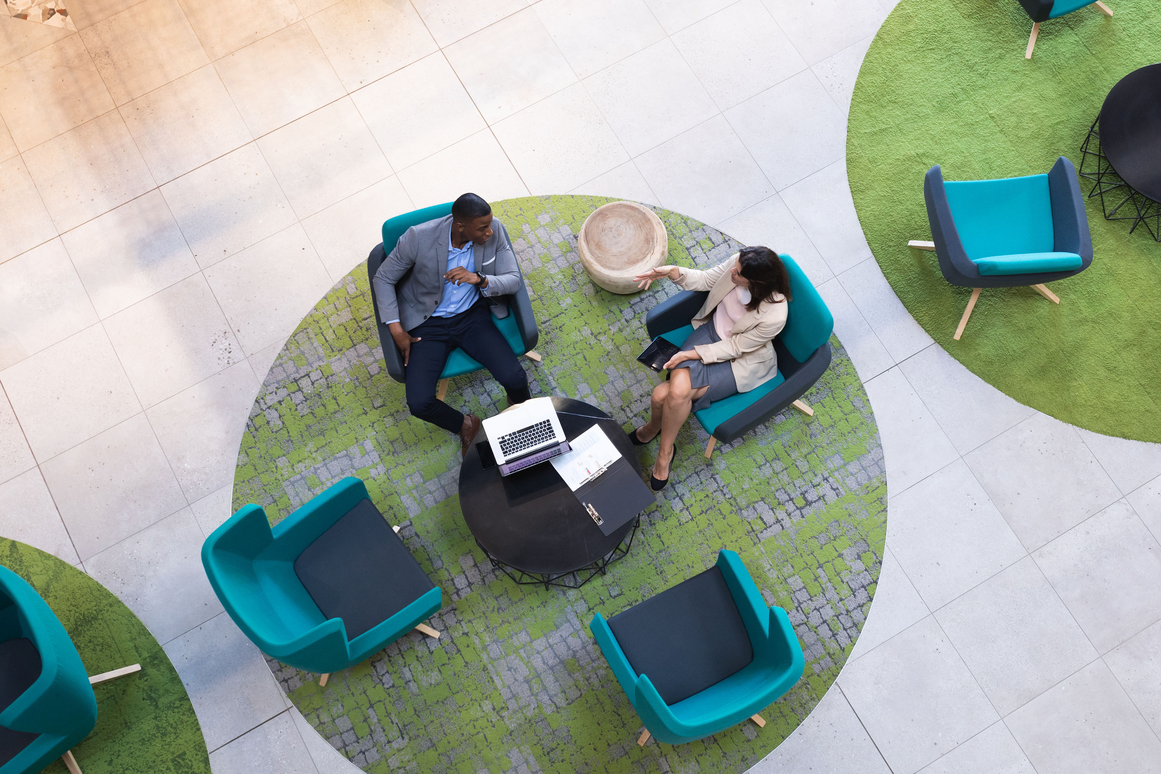 Aerial view of two colleagues talking on chairs