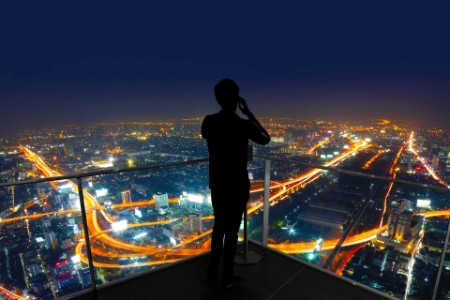 Businessman standing using smart phone on open roof top
