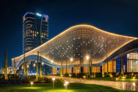 Congress hall and Hilton hotel with colorful illumination at night in Tashkent City Park