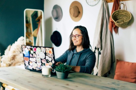 Happy woman works on a laptop