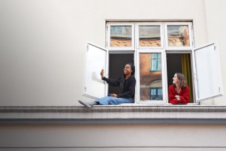 young-women-taking-selfie-in-apartment-ground-floor-window