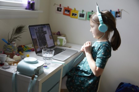 Child learning on laptop with headphones on