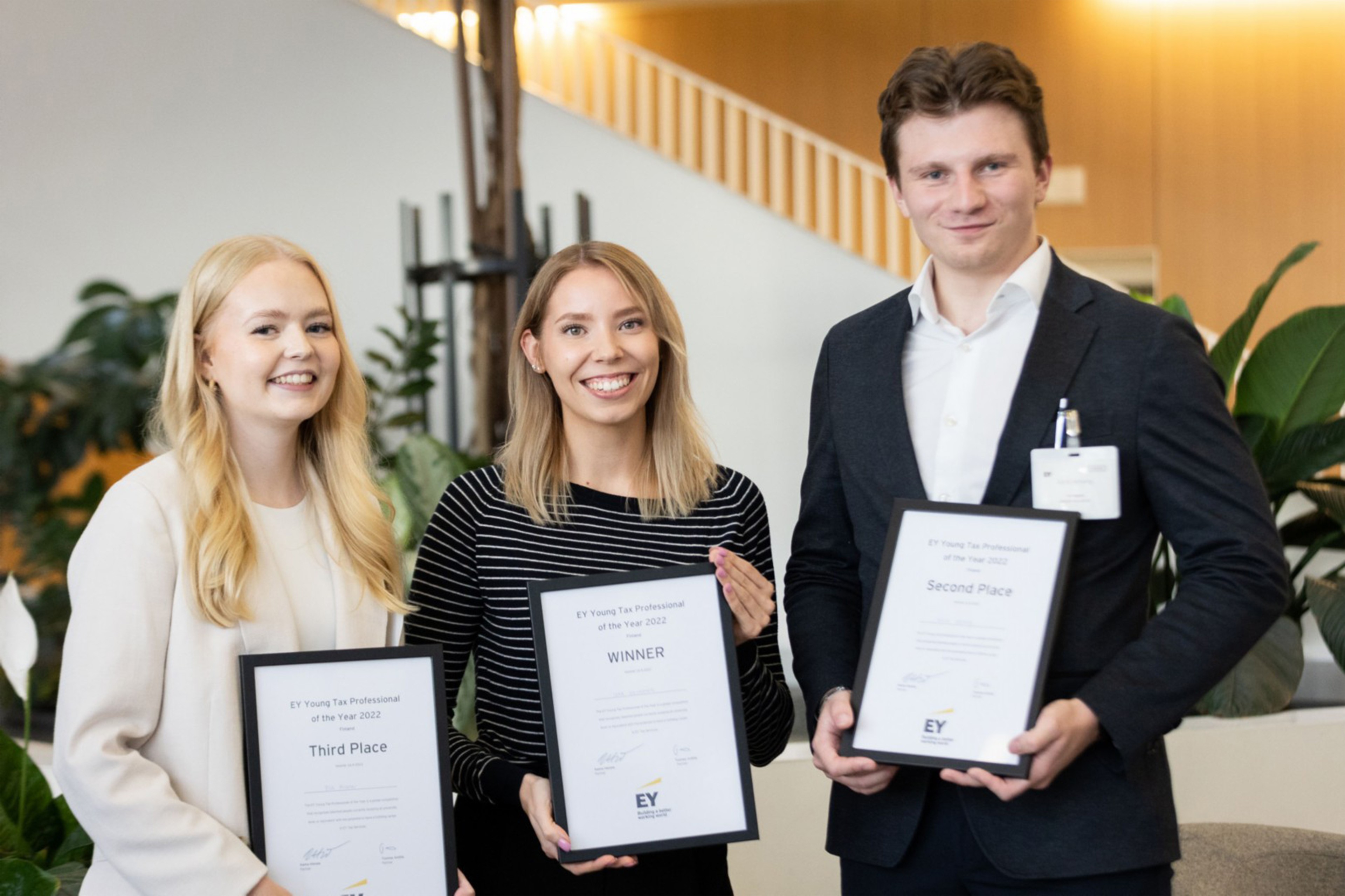 EY:n Suomen Young Tax Professional of the Year -kilpailun top 3 pitelemässä heidän sertifikaattejaan.