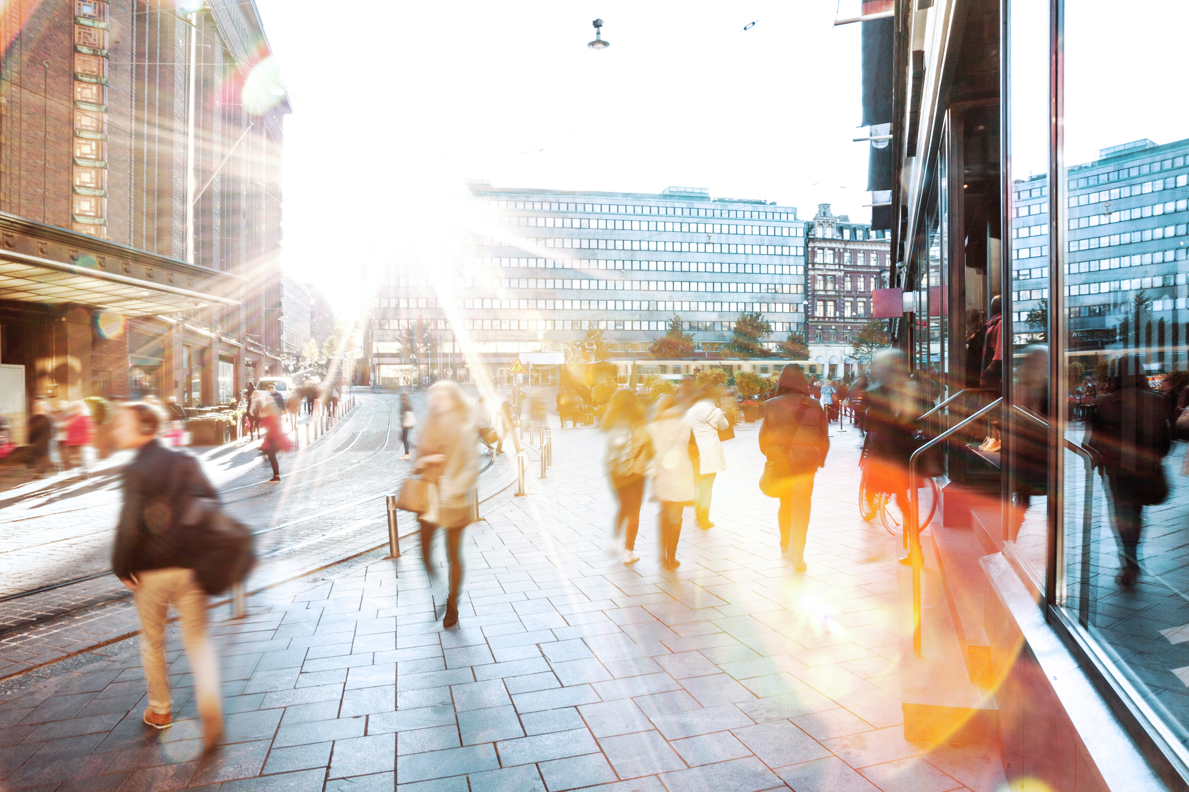 Ihmisiä kulkemassa Helsingin keskustassa auringonpaisteessa