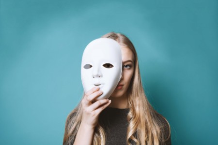 Femme cachée derrière un masque