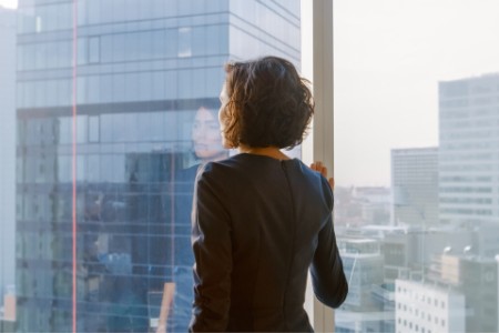 Personne regardant par la fenêtre du bureau.