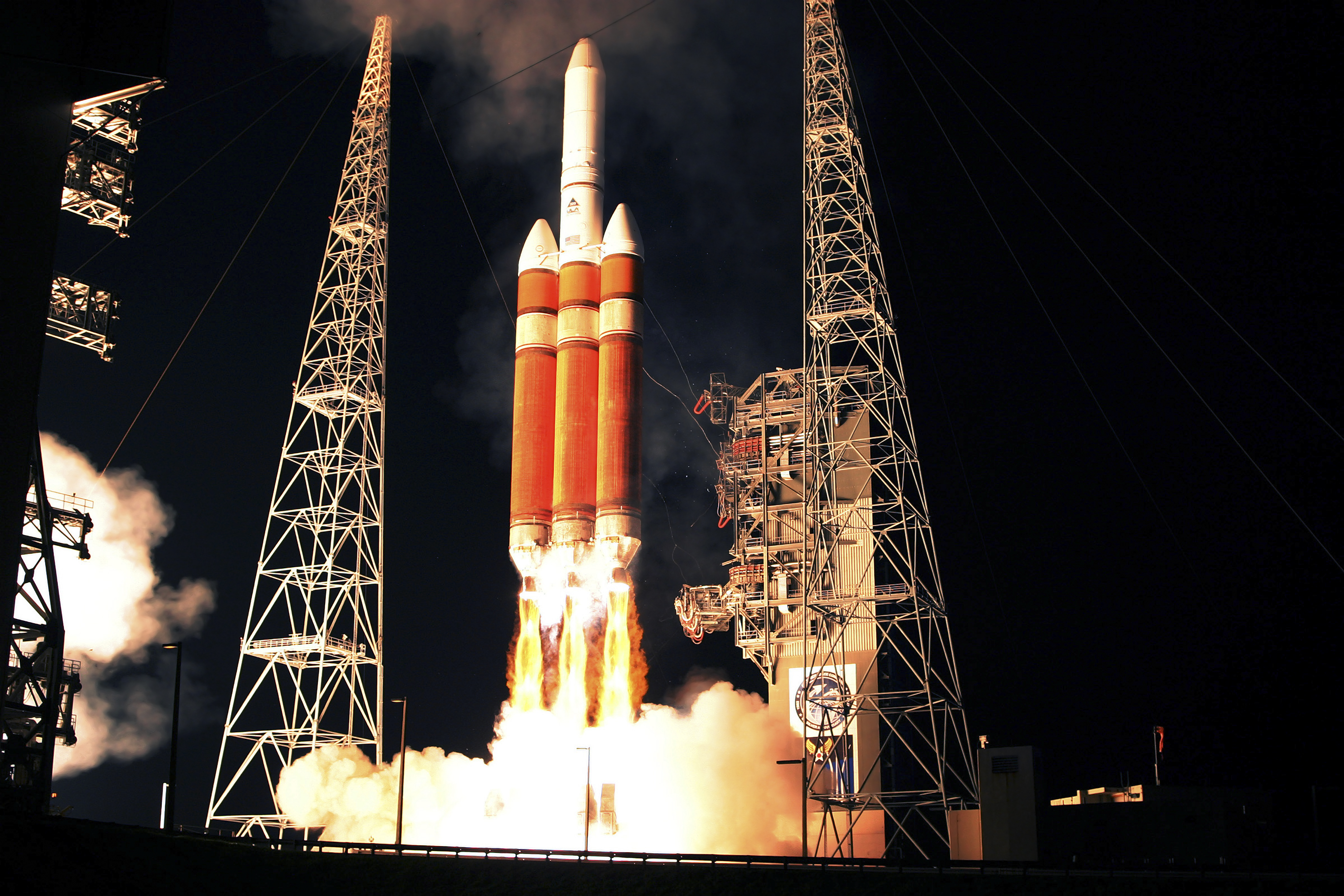 A Delta IV Heavy rocket lifts off late in the evening