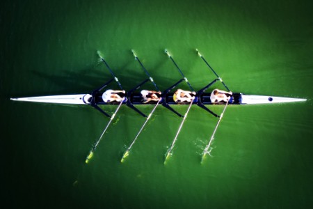 People Rowing Boat In Water