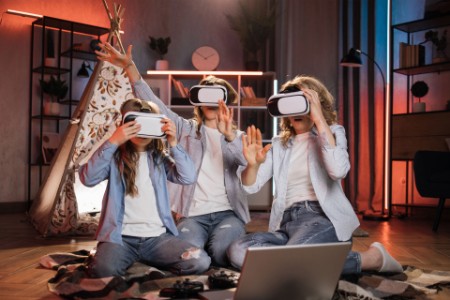 mother and daughters at home using modern VR headset