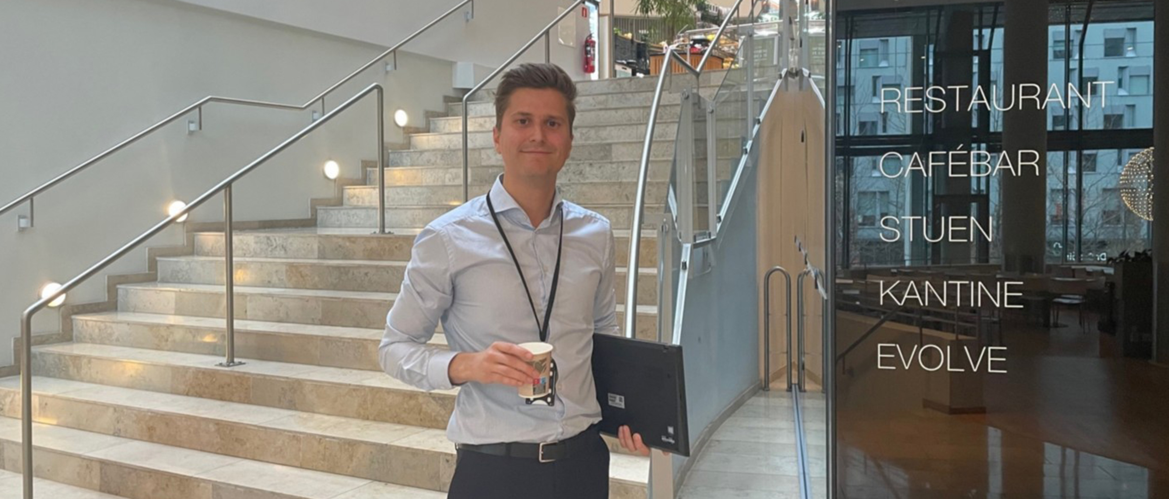 Morten Marcelius Skordal på Oslo-kontoret med PC og kaffekopp i hendene