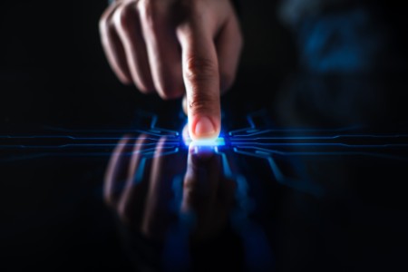 Bilde av en finger som trykker på en skjerm som blir blå og sprer linjer ut fra trykkområdet