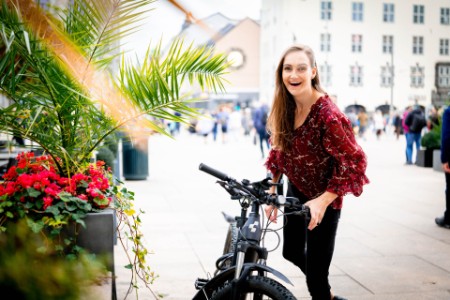 Kristina D. Sakariassen med sykkel ved blomsterbutikk