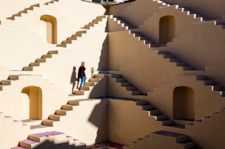 Young woman climbs staircase maze