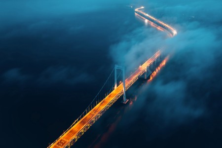 Вид сверху на освещенный мост над морем