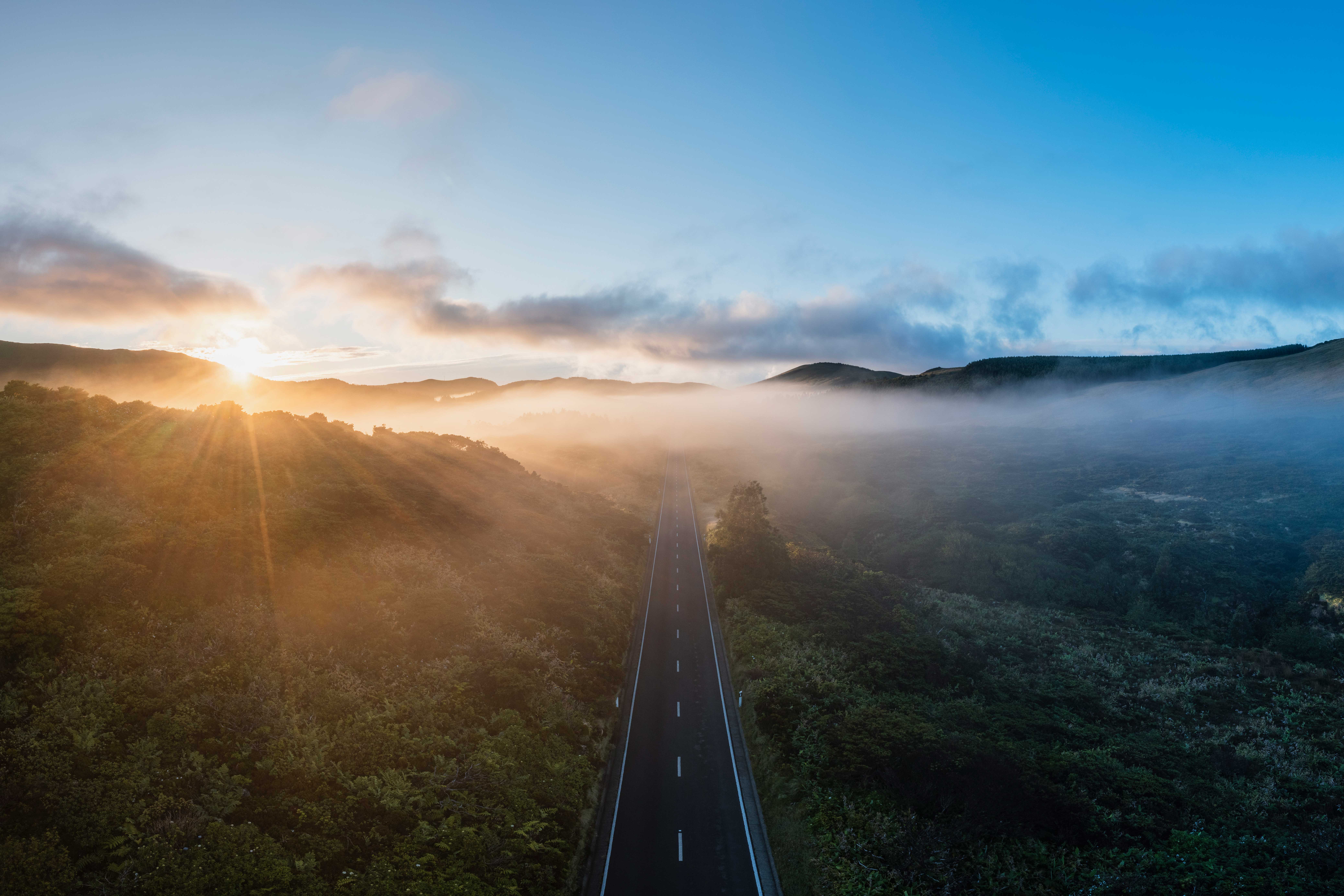 Mountain road in the fog at sunrise