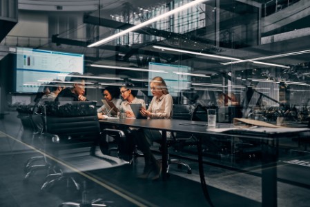 business women and men working in a conference room working on a project presentation