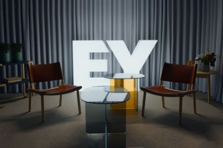 Round table discussion with empty chairs and ey logo on background