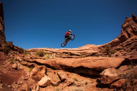 En man får luft när han hoppar på sin mountainbike nära Moab Utah