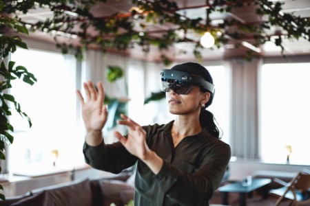 Kvinna håller upp händerna framför sig medan hon använder VR-glasögon