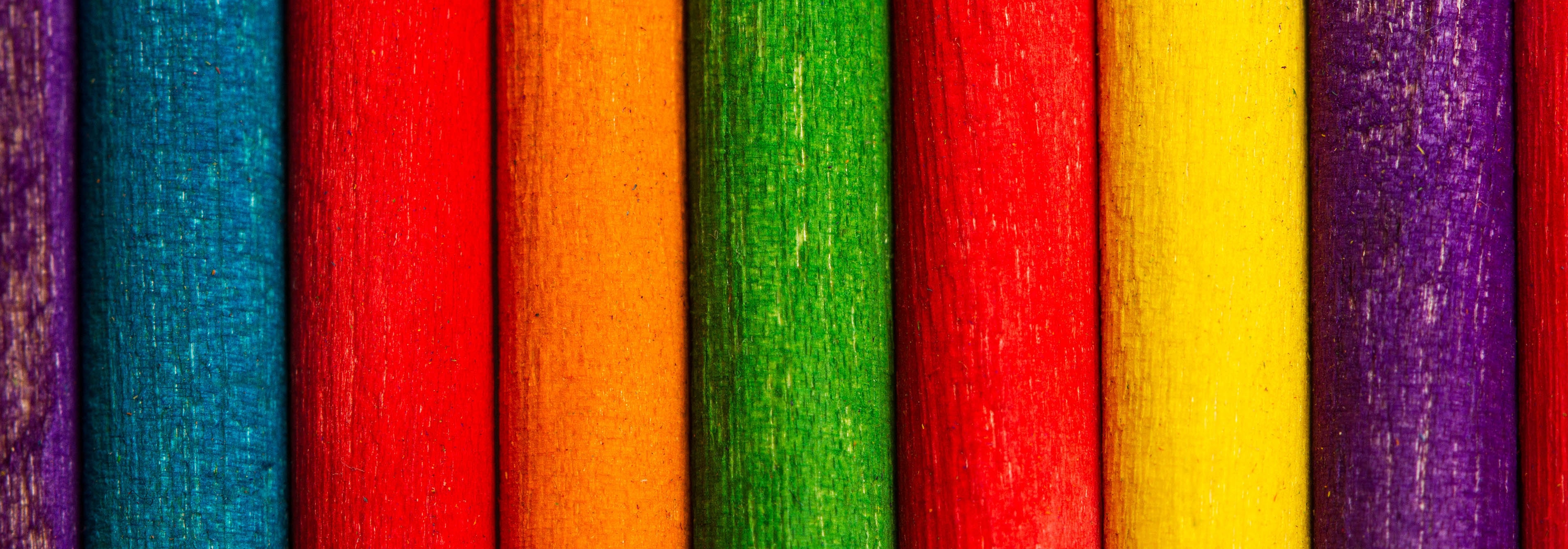 Palos de madera de colores colocados uno al lado del otro. Vista superior y de cerca