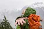 Kvinnlig vandrare breder ut armarna för att omfamna bergsdimma