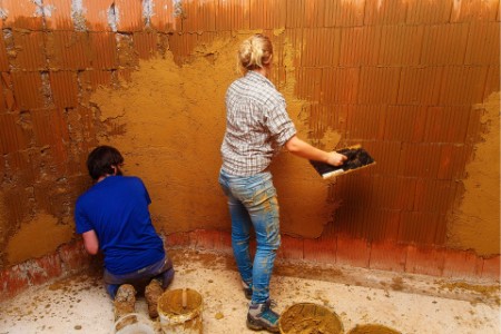 En man och en kvinna som jobbar med lera