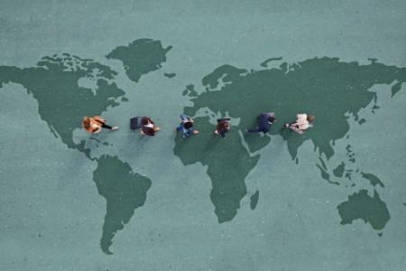 Business people walking across world map